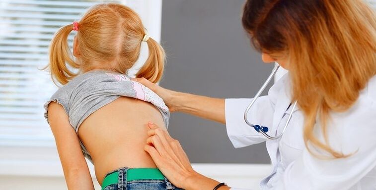 doctor examining child's back for lower back pain